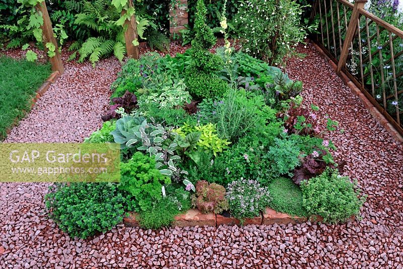 Herb bed with red brick and gravel surround - RHS Tatton Park Flower show 2010