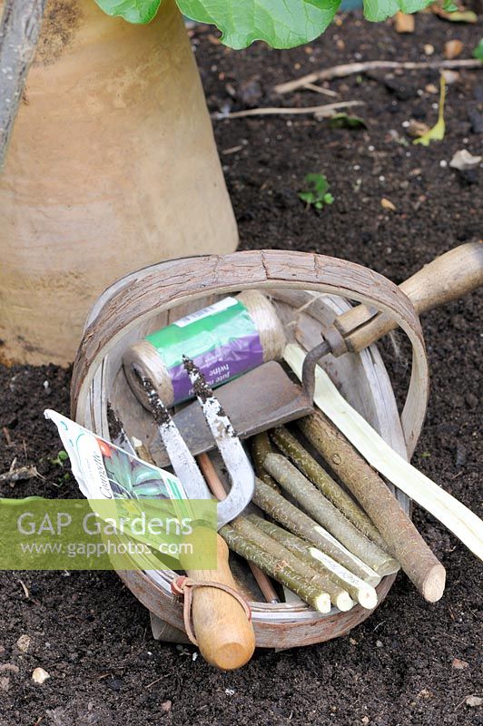 Wooden trug with hazel stick markers, garden twine, seeds and tools