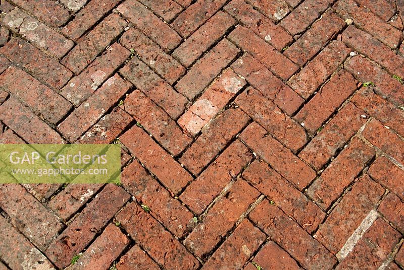 Herringbone block paving as garden path, made from old red bricks