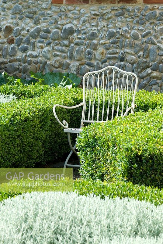 Child's chair in the formal knot garden with Santolina and Buxus hedging - Heveningham, Suffolk