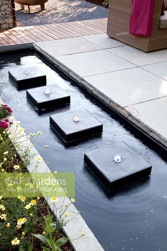 Modern rectangular pond with row of square water features