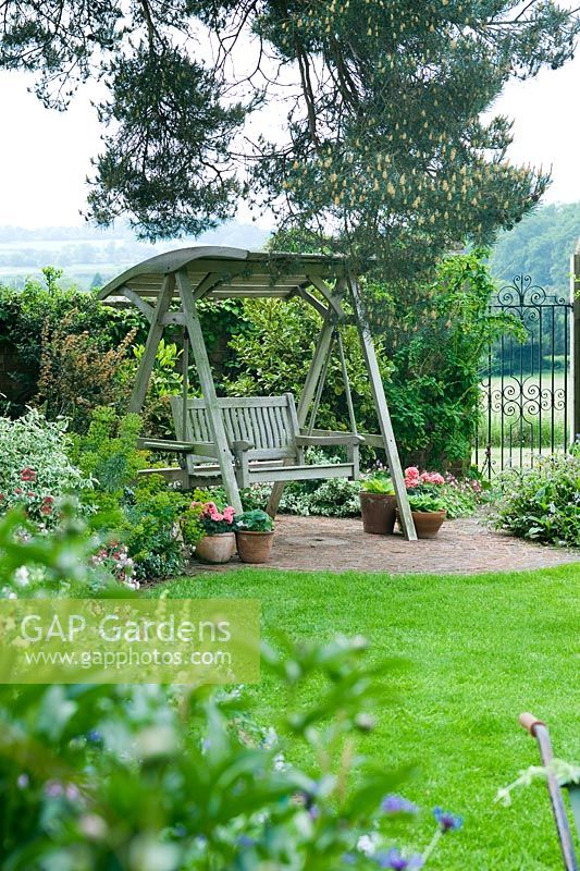Covered wooden swing seat and paved area. Dawn End Lodge NGS 