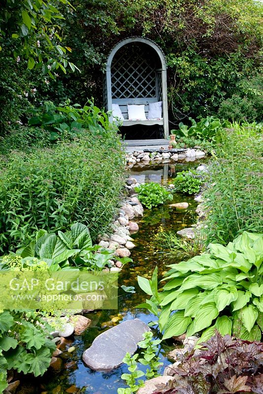 Stream running through garden with view to arbour