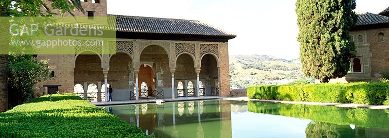 Overlooking the Partal gardens with rectangular pools and topiary hedges - Gardens of the Alhambra, Granada, Spain