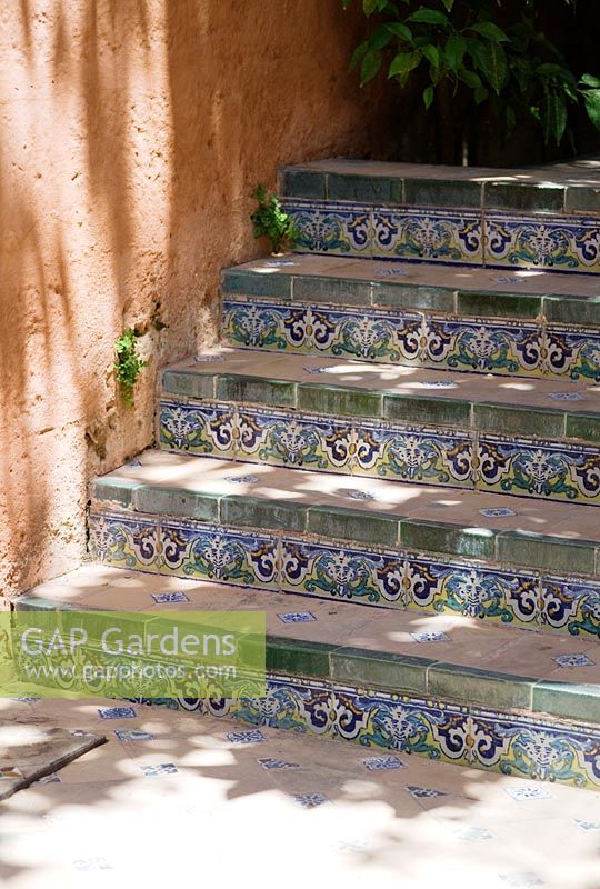 Decorative painted tiles edging steps in a mediterranean garden