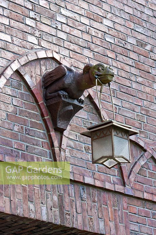 Detail of an expressionistic gargoyle holding a lantern - The Manor House, Germany
