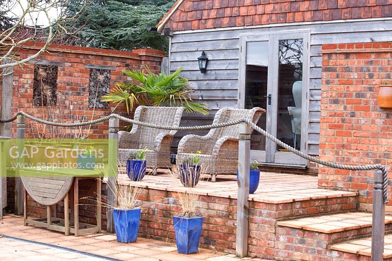 Wicker chairs on raised patio with rope railings 