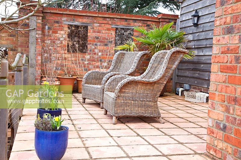 Wicker chairs on raised patio with rope railings 
