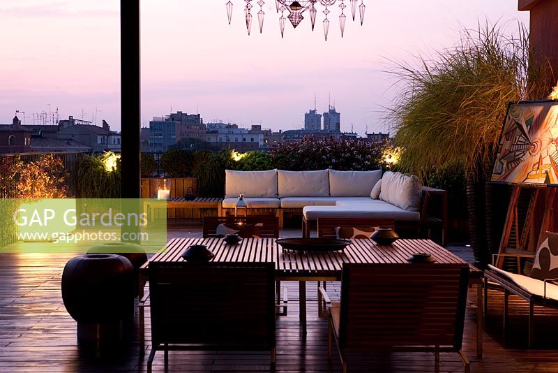 Terrace with contemporary seating area with sofas at night with modern lighting in Ferrara, Italy 