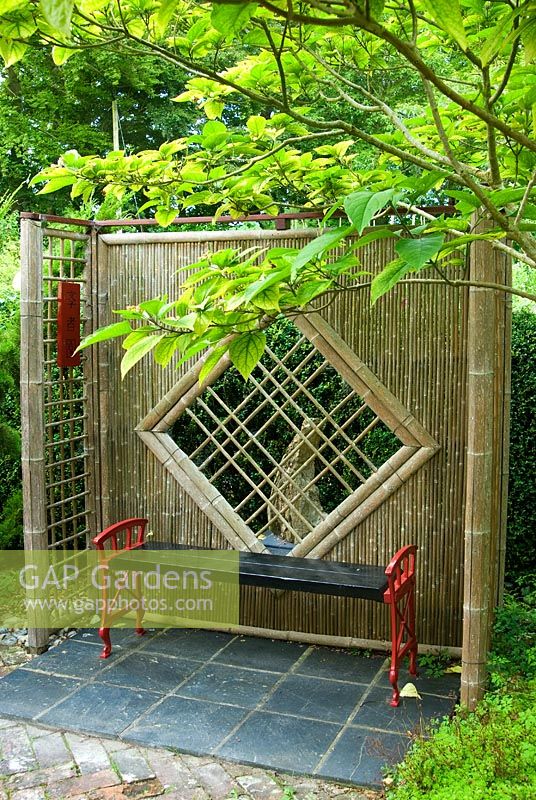 Bamboo screens frame a bench in the Scholar's Garden. Beggars Knoll, Newtown, Westbury, Wiltshire, UK