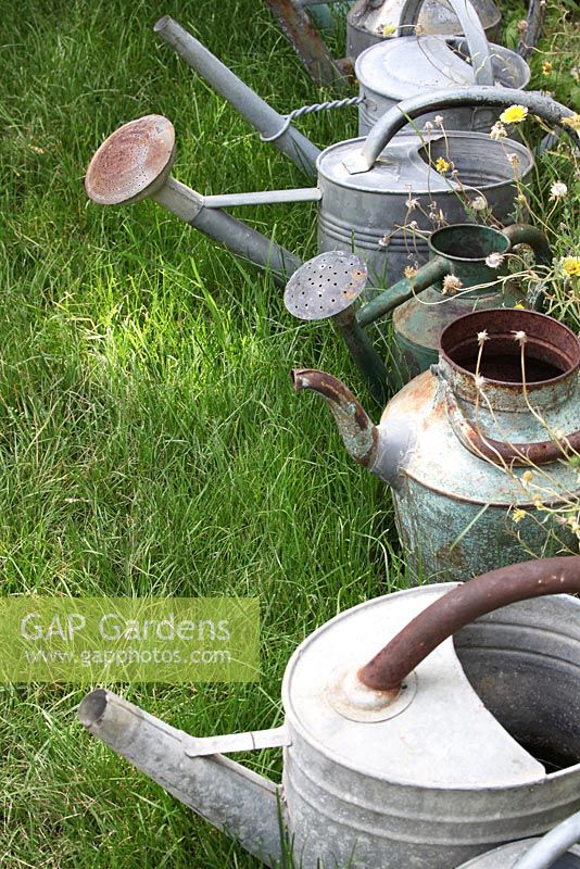 Line of metal watering cans in the 'Sculptillonnage' garden - Festival International des Jardins de Chaumont sur Loire, France 2011
