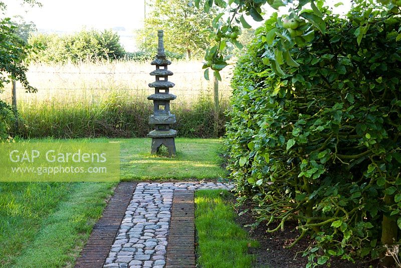 The Corner House, Wiltshire. Summer garden, Japanese temple at end of cobble path