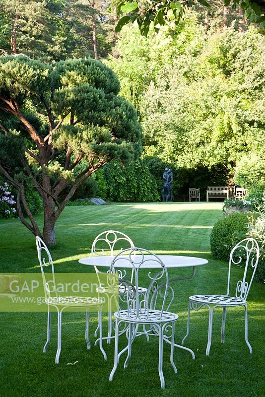 Seating area on lawn in country garden
