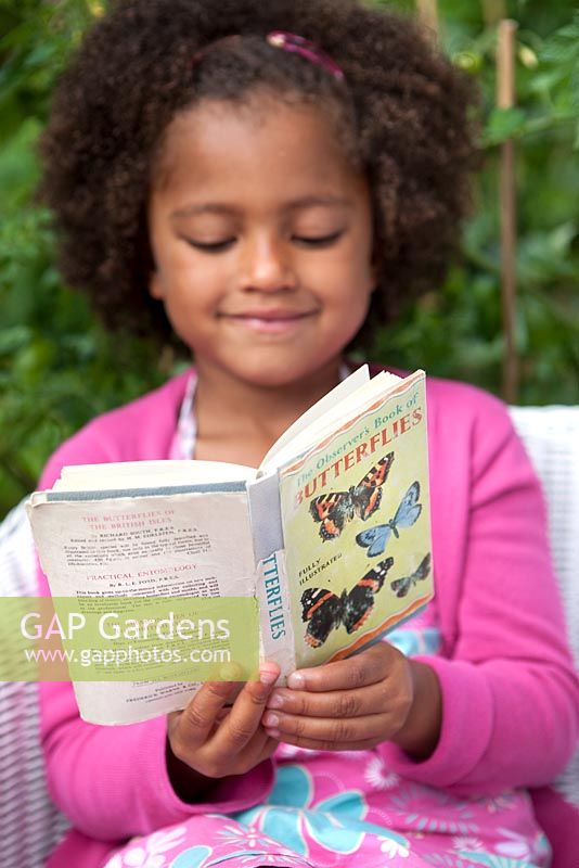 Young girl reading butterflies book