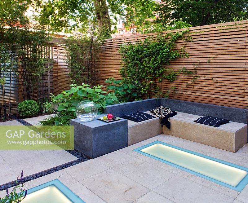 Modern garden with built in lighting and seating area 

