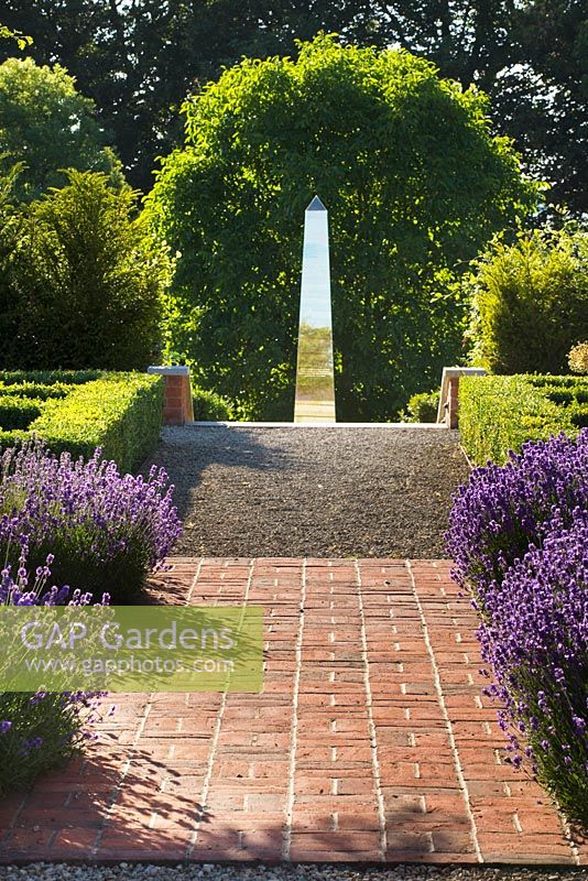 Red brick Lavandula - Lavender, edged path leading to metal sculpture, Oxfordshire 
