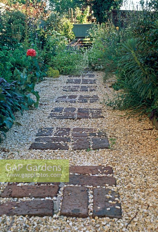Gravel garden path with pattern of bricks 