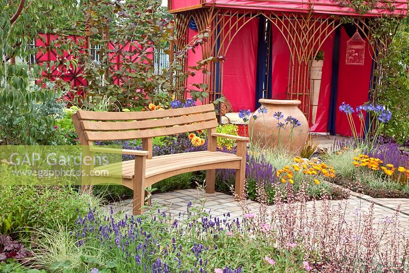 Bench in garden with modern red gazebo 