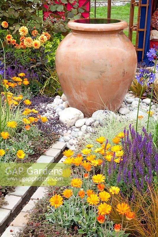 Water feature and decorative terracotta urn in garden 