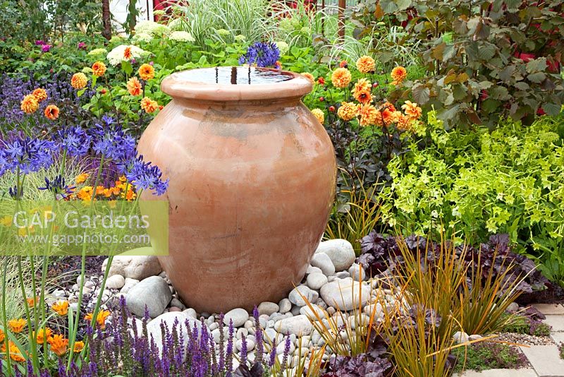 Decorative urn water feature in Mediterranean style garden 
