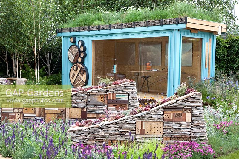Sculptural dry stone walls with built-in insect hotels and planted with Sempervivums - Houseleeks in front of turquoise summerhouse - 'The Royal Bank of Canada with the RBC New Wild Garden' - Silver Gilt Medal Winner, RHS Chelsea Flower Show 2011