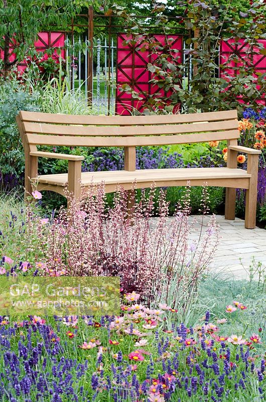 Wooden bench surrounded by mixed summer planting of Heuchera 'Plum Pudding', Artemisia schmidtiana, Cosmos bipinnatus 'Dazzler' and Lavandula 'Munstead' - LOROS Hospice Garden of Light and Reflection, Silver Medal Winner, RHS Hampton Court Flower Show 2011