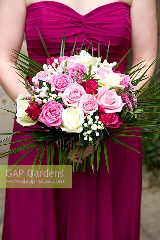 Bridesmaid holding a wedding bouquet of pink and white roses