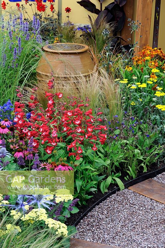 Large, water filled glazed pot in flower beds in the 'Painting With Plants Garden' - RHS Tatton Park Flower Show 2011