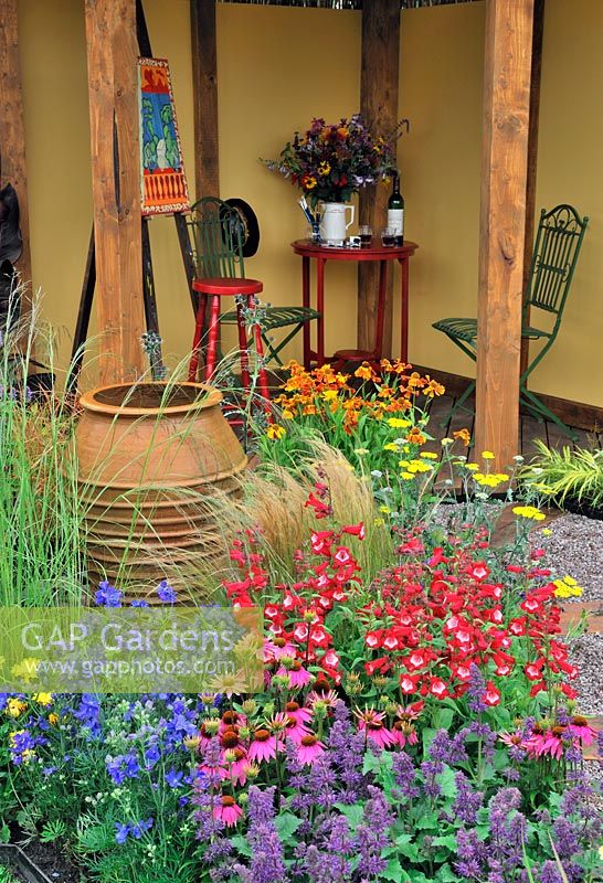 Contrasting and vibrant colour planting with thatched shelter area in the 'Painting With Plants Garden' - RHS Tatton Park Flower Show 2011
