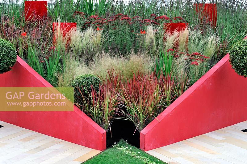 Imperata cylindrica 'Red Baron' with Achillea, Molina and Nasella tenuissima in triangle enclosure with red panels. This is Anfield. RHS Tatton Park Flower Show 2011
