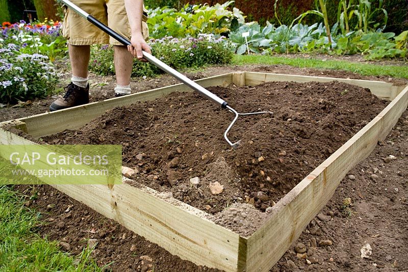 step by step, making a raised bed - levelling soil in raised bed