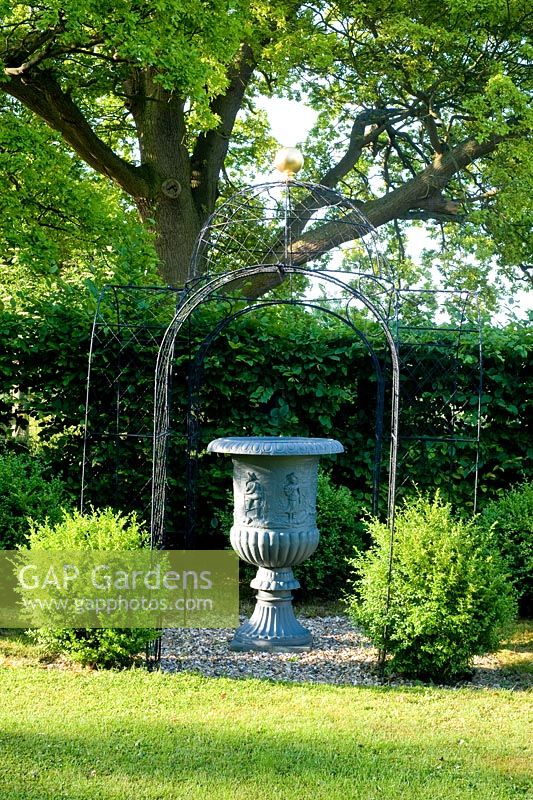 Urn in wire arbor with buxus