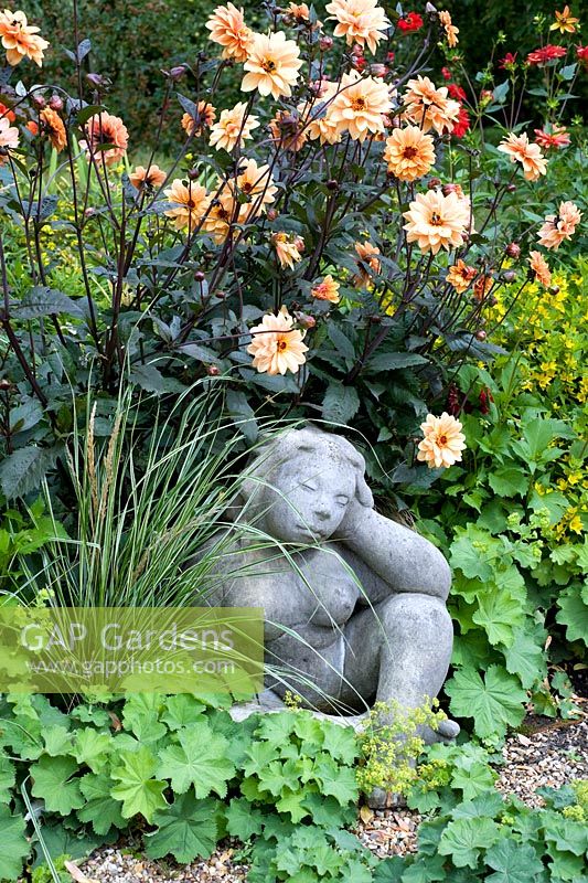 Sculpture in later summer border with Dahlias, grasses and Ricinus - Woodpeckers, Essex NGS
