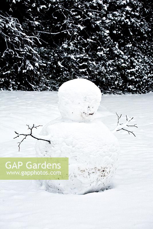 Snowman in winter garden 