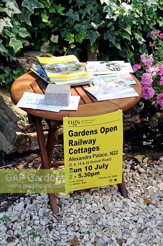 Sign hanging from table saying Railway Cottages, Gardens Open for the National Garden Scheme  