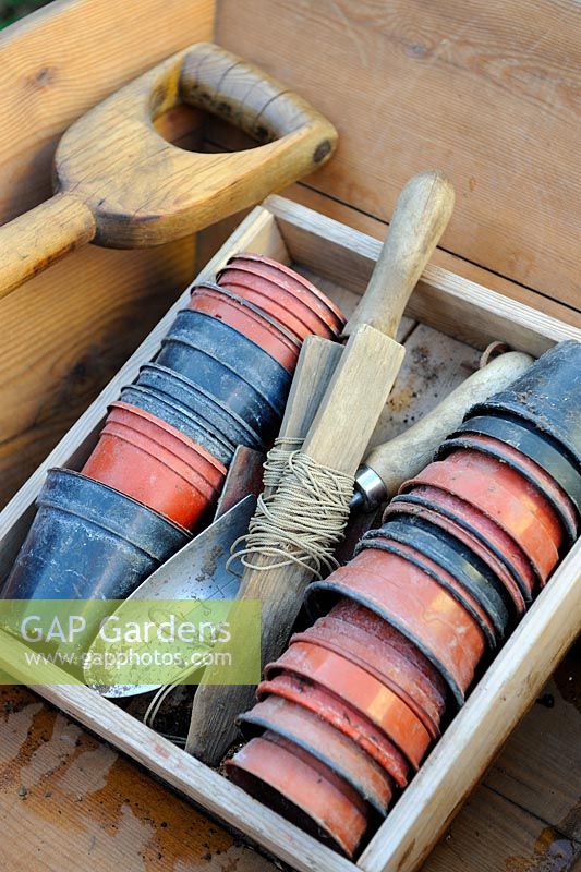 Wooden seed tray with plastic pots, garden line and hand tools