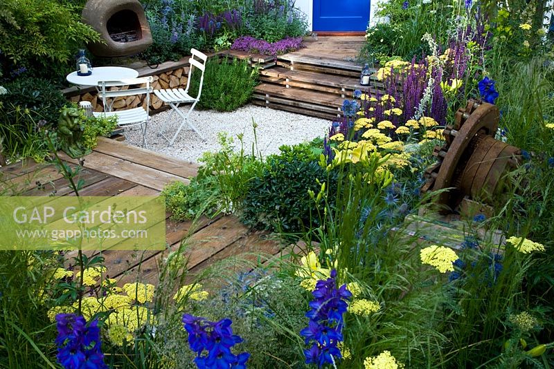 A garden for a young couple with a budget of £7000. Reclaimed scaffold boards and split logs predominate - 'Our First Home, Our First Garden' - Gold medal winner - RHS Hampton Court Flower Show 2012 
