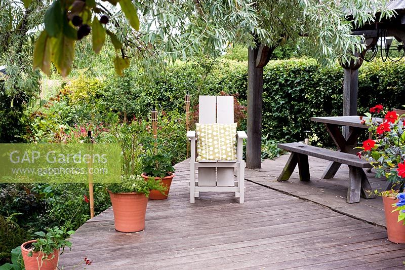 Raised deck with adirondack chair, pots and candles - Brook Hall Cottages, Essex NGS