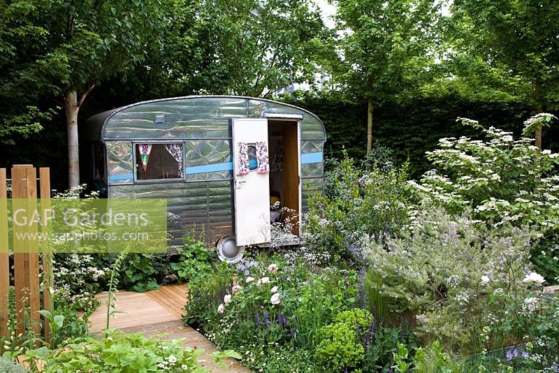 A garden based around a 50s aluminium caravan - Roses, salvias, irises, grasses. Water rill doubles as a wine chiller.