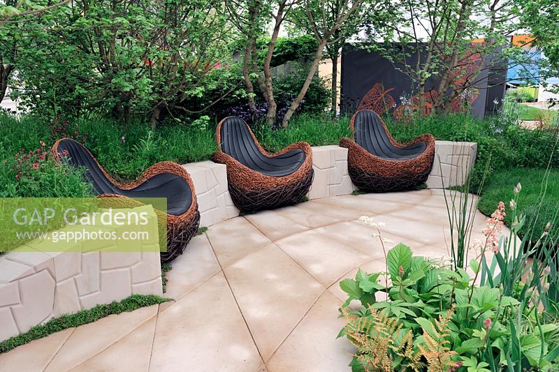 Tranquillity set in Stone. Bronze Medal Winner. Chelsea Flower Show 2012. Sandstone patio with willow woven seats.