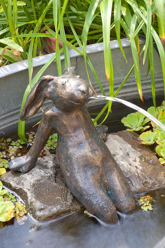 Bronze hare in fountain water feature 