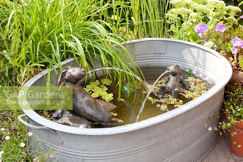 Bronze hare fountains in homemade water feature 