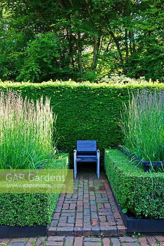 The Cornfiled Garden with Calamagrostis acutifora 'Overdam' with lettering on rails. Yew and box Hedges - Veddw House Garden, Monmouthshire, Wales