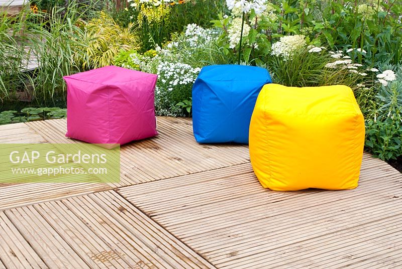 Square colourful bean bags on ornate circular decking in the 'A Taste of Ness' garden, RHS Tatton Flower Show 2012