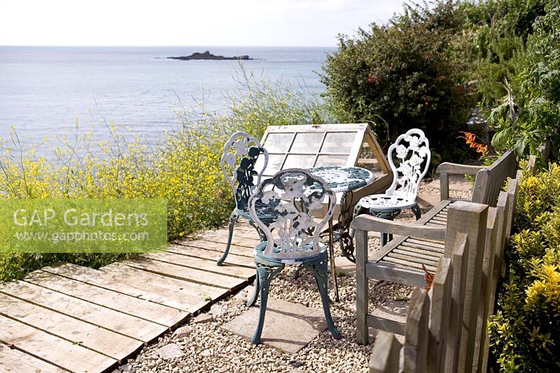 Table and chairs with sea view, Coastal allotment, Mousehole, Cornwall, July, summer