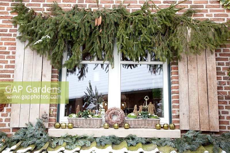 Window decorated for Christmas with pine branches