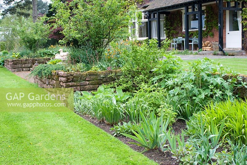 Spring herbaceous beds and adjacent lawn - Abbeywood Gardens, Cheshire