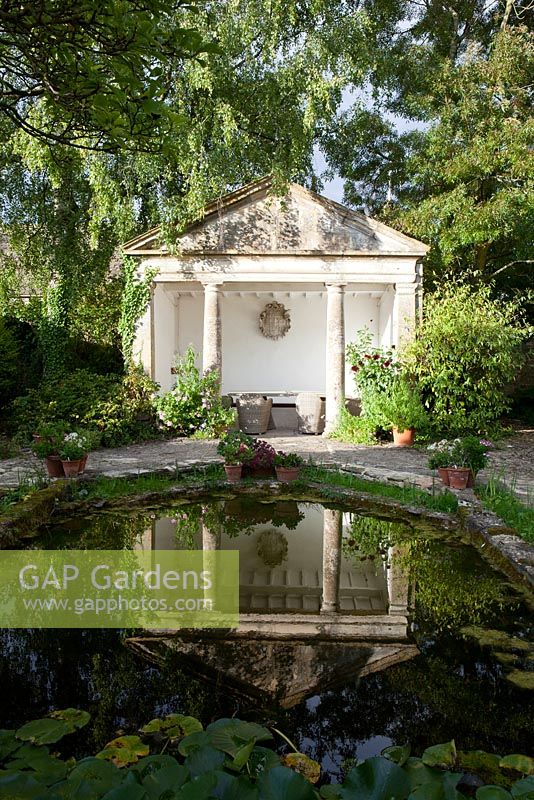 The classical summerhouse and pond at Barnsley House Garden in Gloucestershire