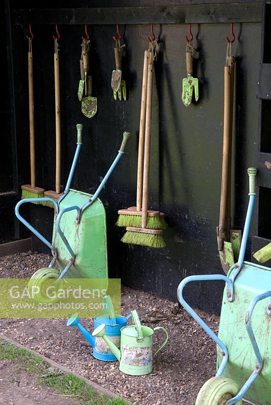 Store for childrens' gardening equipment, including wheelbarrows, brooms, trowels, hand forks, spades and watering cans - Felbrigg Hall, Norfolk NT