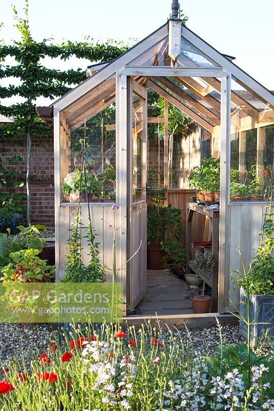 Wooden greenhouse in potager in summer